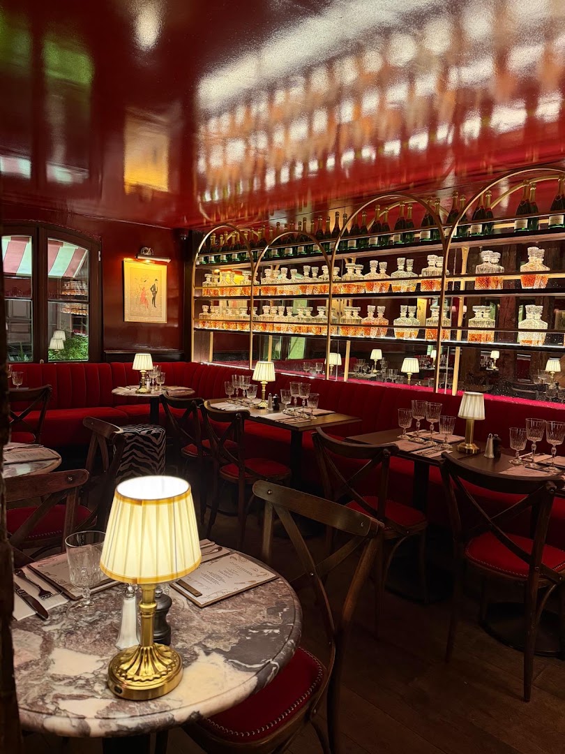 Salle aux banquettes rouges, boiseries et bar éclairé