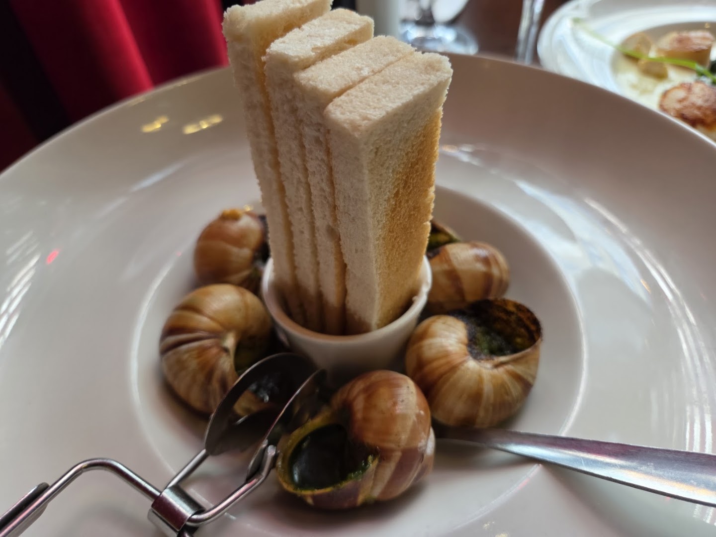 Escargots et tranches de pain servis dans une grande assiette